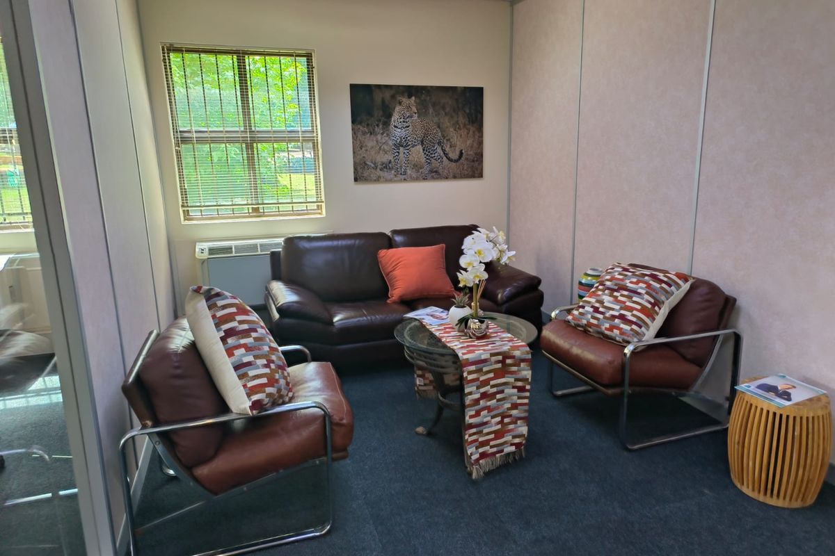 A compact office space featuring modular partition walls, carpeted flooring, and an integrated HVAC unit, suitable for a private meeting or consultation area.