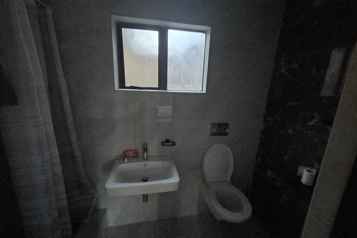 A compact bathroom featuring a wall-mounted basin, wall-hung toilet with concealed cistern, and tiled finishes.