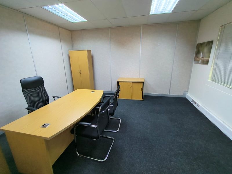 A functional office space featuring carpeted flooring, suspended ceiling with recessed lighting, and partition walling, suitable for a professional work environment.