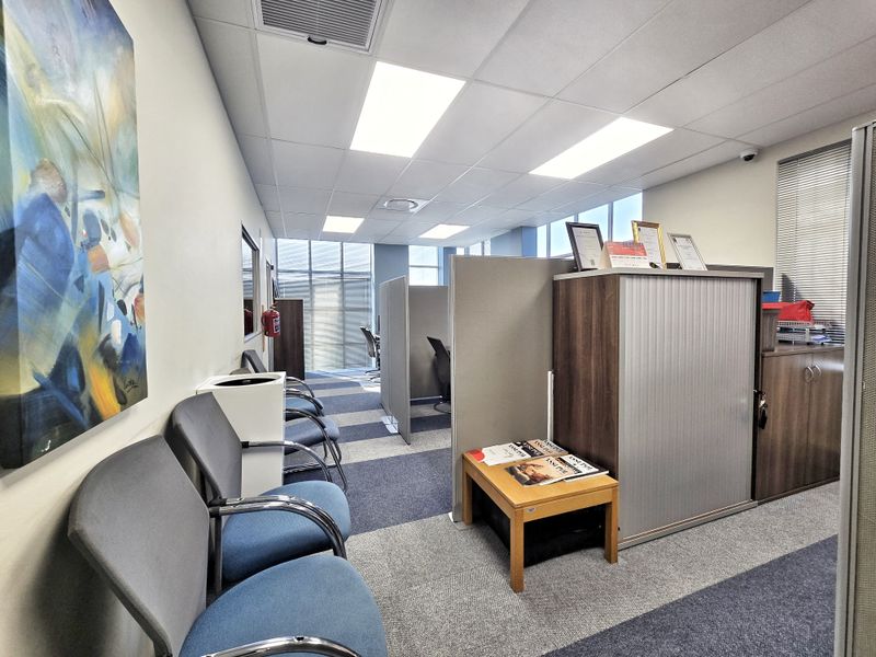 A professional office space featuring modular partition walls, suspended ceilings with recessed lighting, and durable carpet flooring.