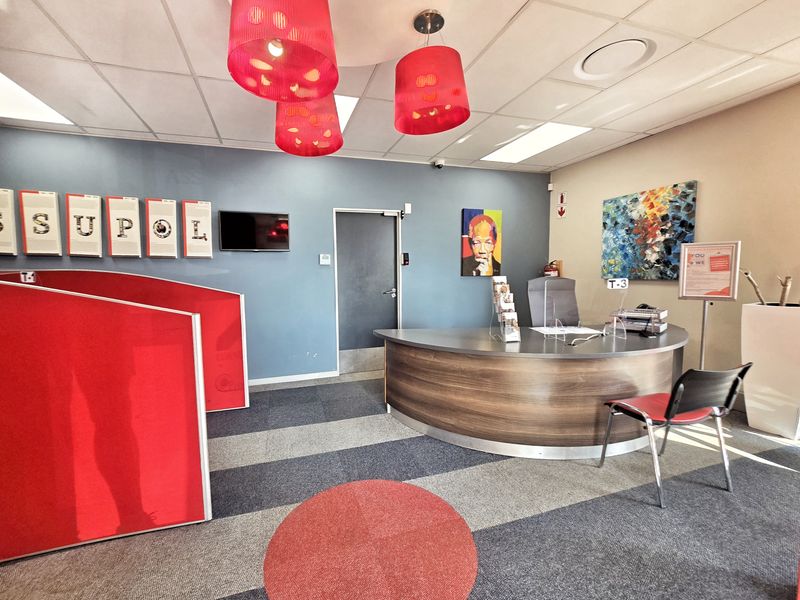 A professional office reception area featuring a curved built-in desk, suspended ceiling, and modern partition walls.