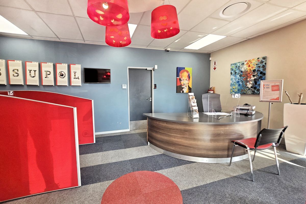 A professional office reception area featuring a curved built-in desk, suspended ceiling, and modern partition walls.