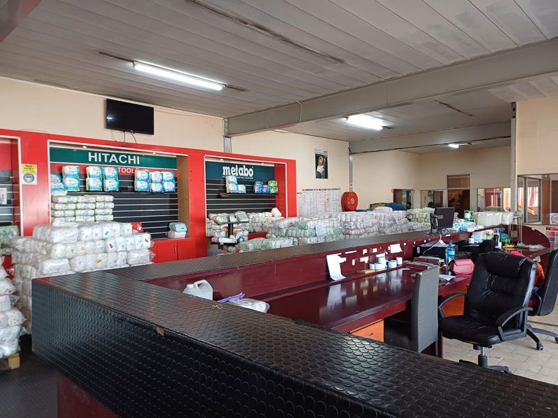 Industrial utility space featuring a large service counter, slatted display shelving, and functional overhead lighting, suitable for retail or warehouse operations.
