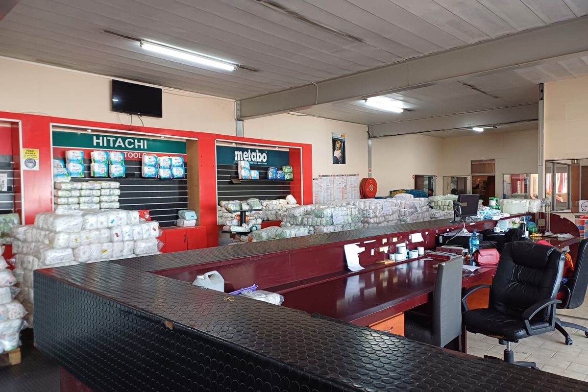 Industrial utility space featuring a large service counter, slatted display shelving, and functional overhead lighting, suitable for retail or warehouse operations.