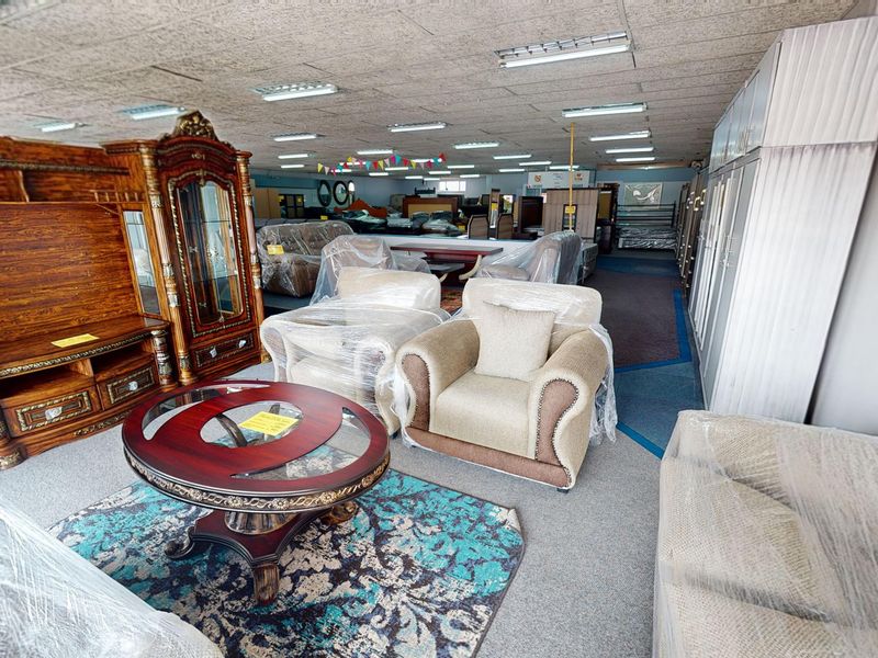 A large commercial showroom space featuring acoustic ceiling tiles, fluorescent lighting, and extensive floor area suitable for retail display.