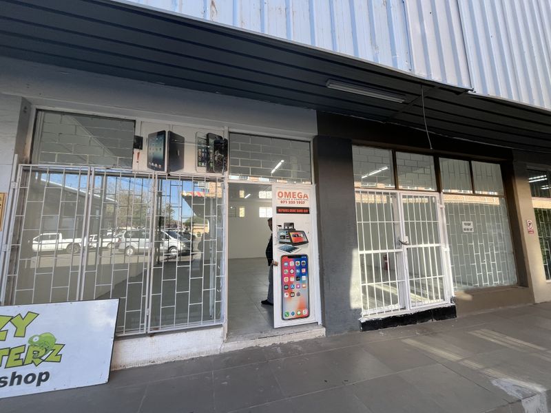 Front exterior view of a retail storefront featuring security gates and a metal facade, suitable for a small business or service shop.