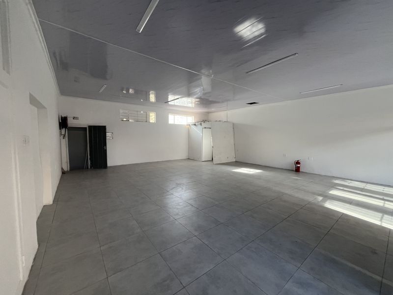 Spacious open-plan retail area featuring tiled flooring, glossy ceiling panels, and integrated lighting, suitable for various commercial business applications.