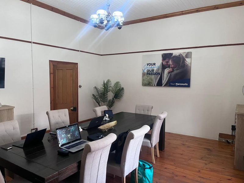 A professional office space featuring polished timber flooring, classic timber trim details, and a traditional beaded ceiling finish.