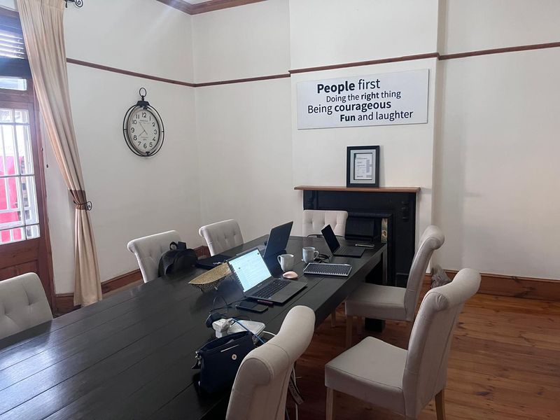 A professional office space featuring original timber flooring, a classic fireplace, and traditional picture rails, providing a character-filled environment for business operations.