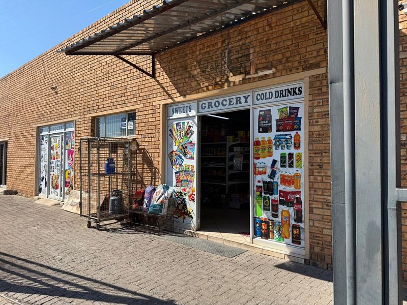 Commercial storefront featuring a face brick facade, metal awning, and glass entrance doors with retail signage.