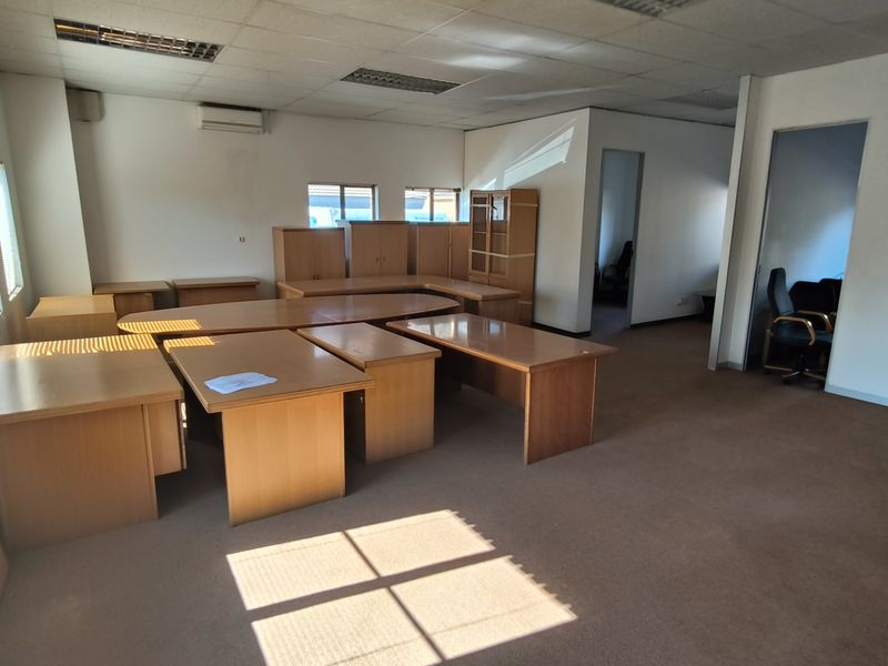 Spacious office area featuring suspended ceilings, recessed lighting, air conditioning, and carpeted flooring, offering a functional workspace layout.