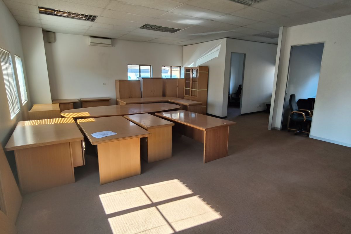 Spacious office area featuring suspended ceilings, recessed lighting, air conditioning, and carpeted flooring, offering a functional workspace layout.