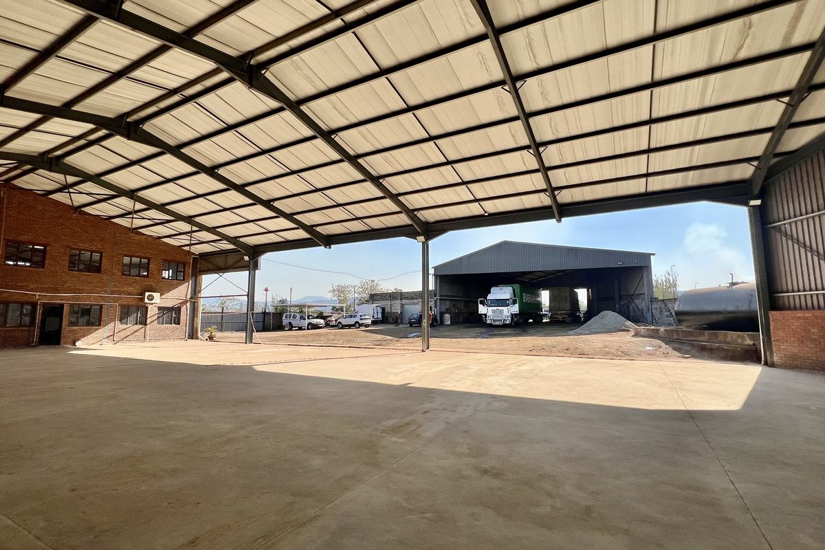 Spacious industrial warehouse featuring a high-clearance steel portal frame, durable concrete flooring, and exposed brick walls, ideal for logistics or manufacturing operations.