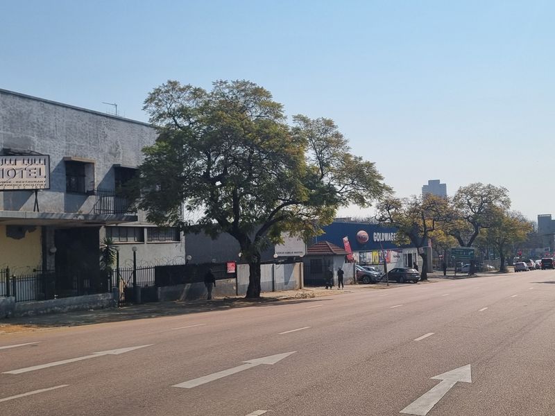 A street-level view showing the exterior of a commercial building and surrounding road infrastructure in an urban setting.