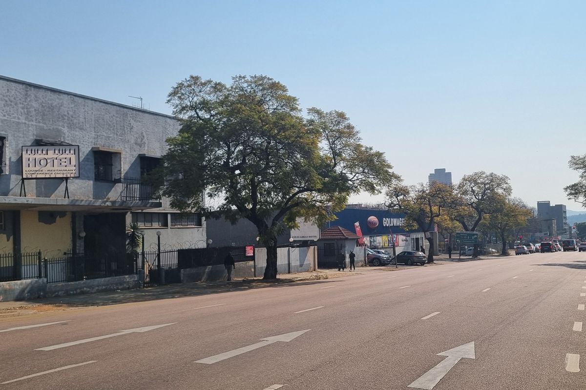 A street-level view showing the exterior of a commercial building and surrounding road infrastructure in an urban setting.