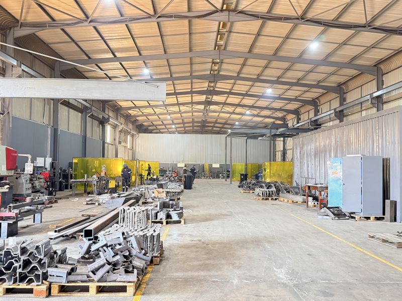 Spacious industrial warehouse facility featuring a high-clearance steel portal frame, durable concrete flooring, and integrated welding bays for manufacturing operations.