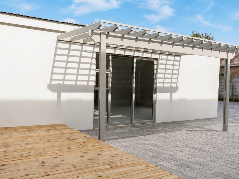 A modern outdoor entertainment area featuring a timber deck, a structural pergola, and paved patio space with sliding door access to the building.