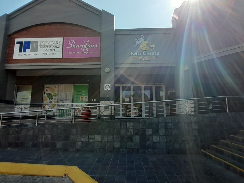 Front elevation of a commercial office and retail complex featuring stone-clad ramp access, metal handrails, and glass storefront entrances.