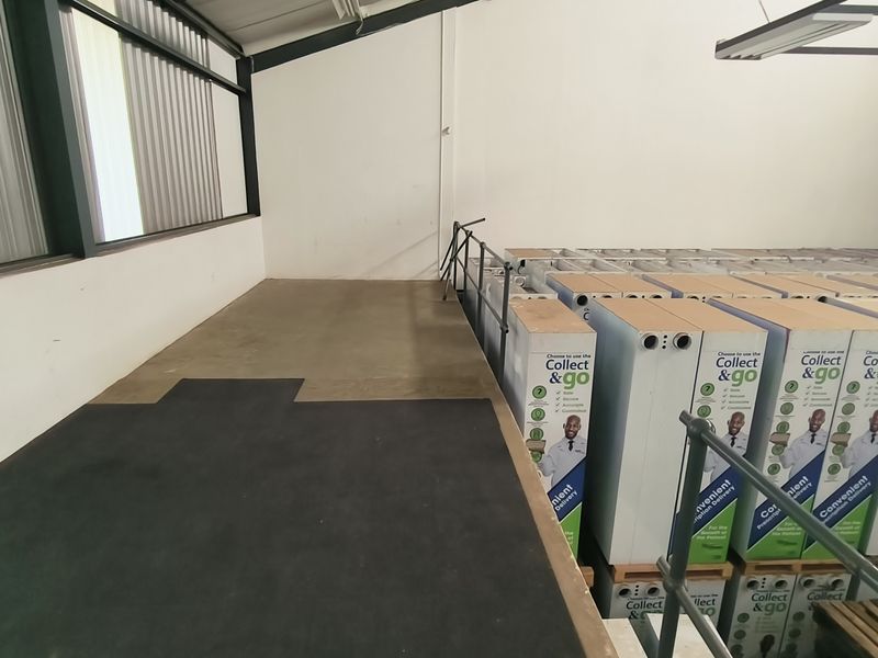 Industrial utility space featuring concrete flooring, metal structural elements, and a raised platform area currently utilized for storage.