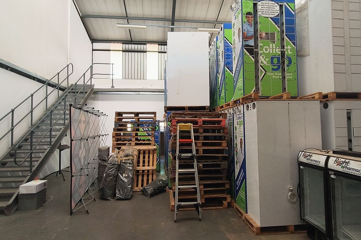 Industrial warehouse space featuring a metal staircase, high ceilings with exposed steel beams, and ample storage capacity for logistics or operational use.