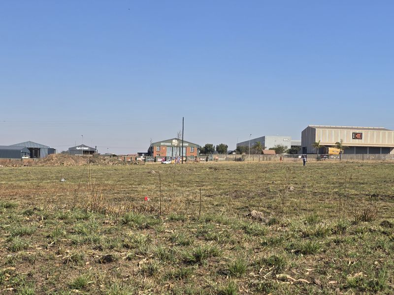 A wide-angle view of a vacant commercial plot of land situated in an established industrial area.