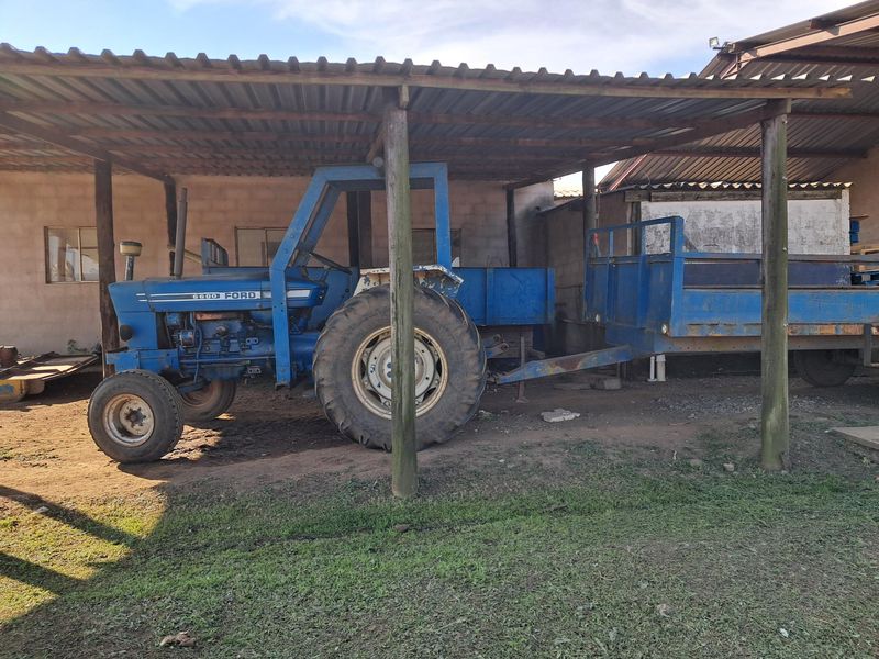 A covered outdoor utility area with a corrugated metal roof and timber support posts, suitable for farm equipment storage.