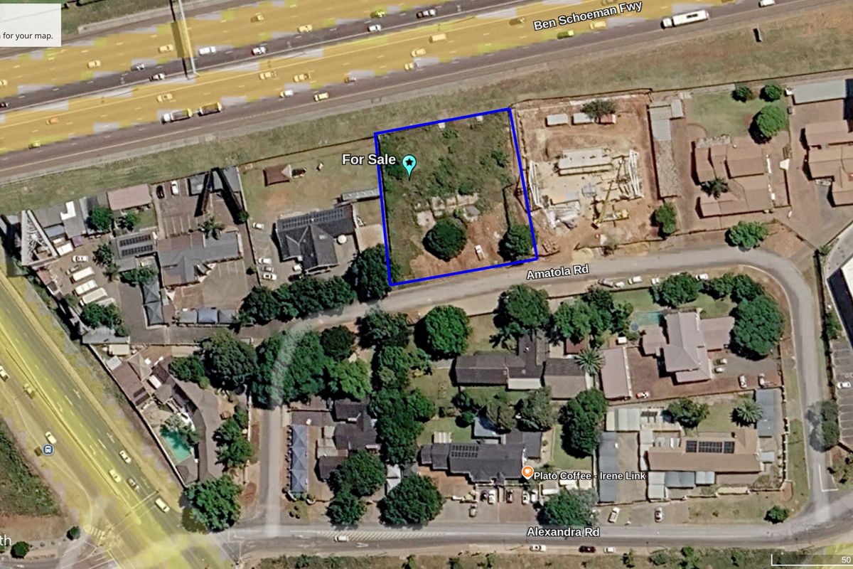 Aerial view of a vacant commercial land plot situated near a major highway and local road infrastructure.
