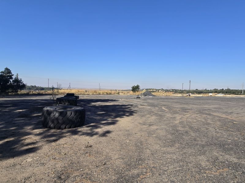 Expansive open industrial yard area with asphalt surfacing, suitable for storage or heavy vehicle maneuvering.