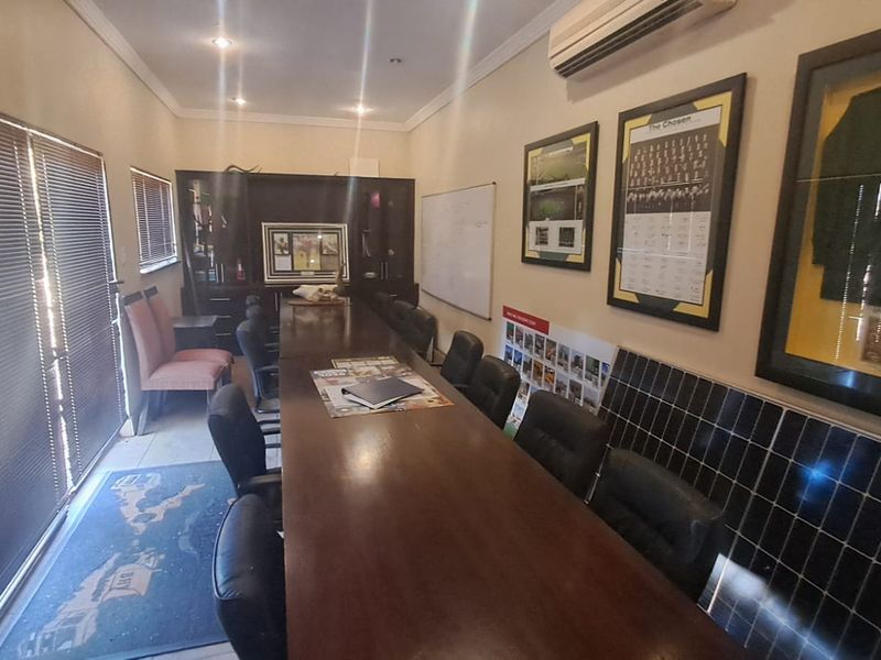 A functional office space featuring built-in cabinetry, recessed lighting, and a split-system air conditioning unit, suitable for professional use.