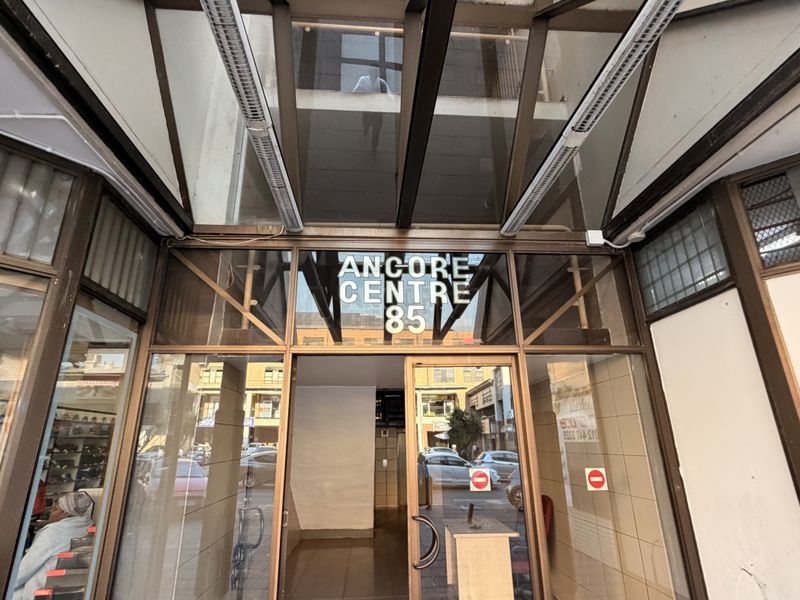 Entrance area of Ancore Centre 85, featuring a glass canopy and aluminium-framed glass doors providing access to the office building.