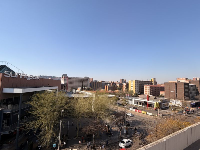An elevated urban view overlooking the Sunny Park shopping center and surrounding commercial district.