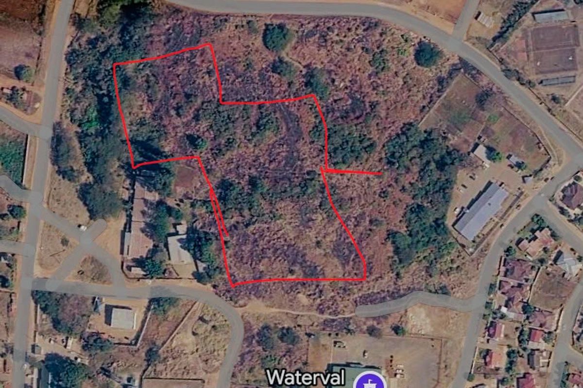 Aerial view of a vacant commercial land plot with red boundary lines indicating the property perimeter.