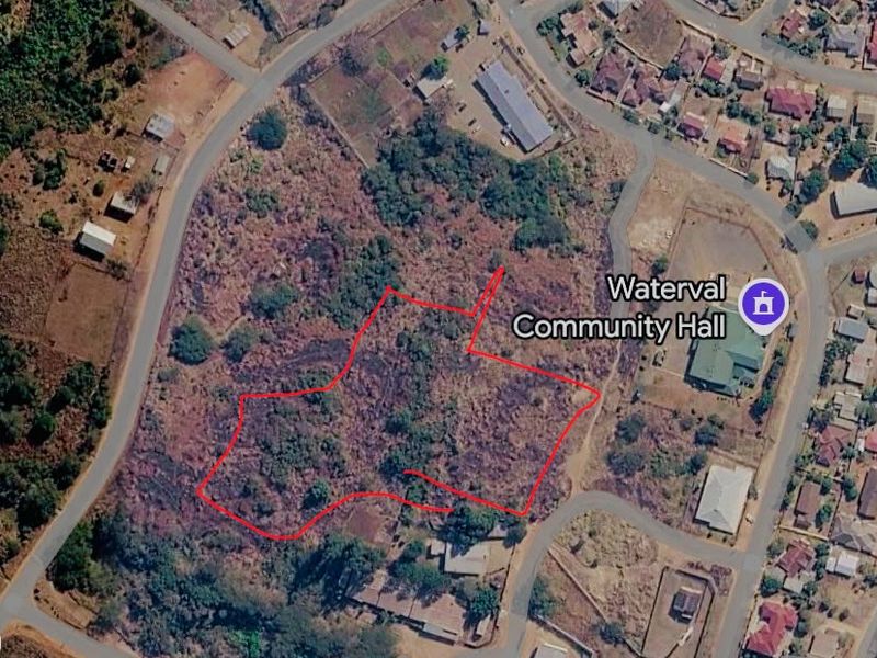 Aerial view of a vacant commercial land plot outlined in red, situated near the Waterval Community Hall and local residential infrastructure.