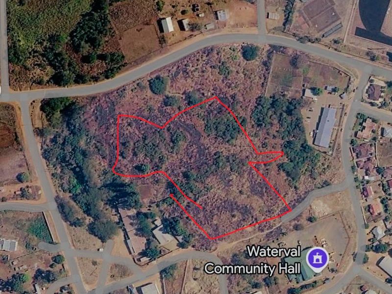 Aerial view of a vacant commercial land plot with road access, located near the Waterval Community Hall.