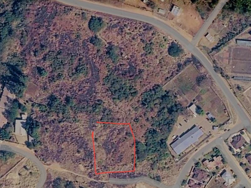 An aerial view of a vacant commercial land plot, highlighting the site boundaries and surrounding neighborhood context.