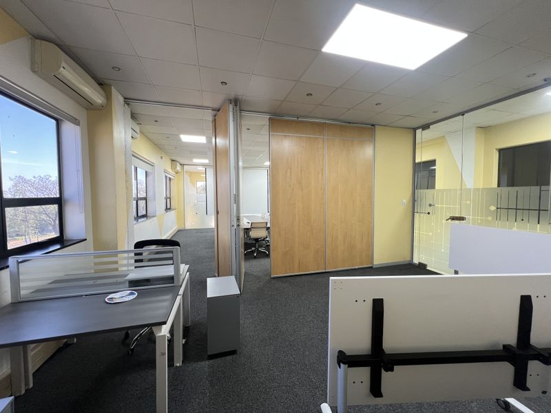 Modern office space featuring a flexible layout with movable acoustic partitions, glass dividers, suspended ceilings, and integrated air conditioning units.