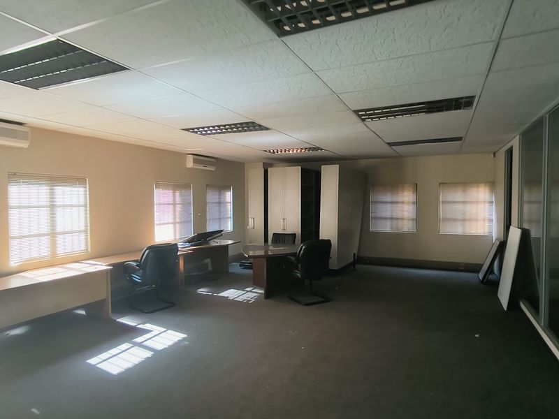 Spacious office area featuring suspended ceilings, recessed lighting, split-system air conditioning, and glass partitions, providing a functional workspace environment.
