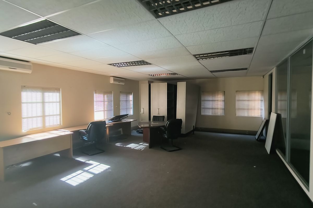 Spacious office area featuring suspended ceilings, recessed lighting, split-system air conditioning, and glass partitions, providing a functional workspace environment.