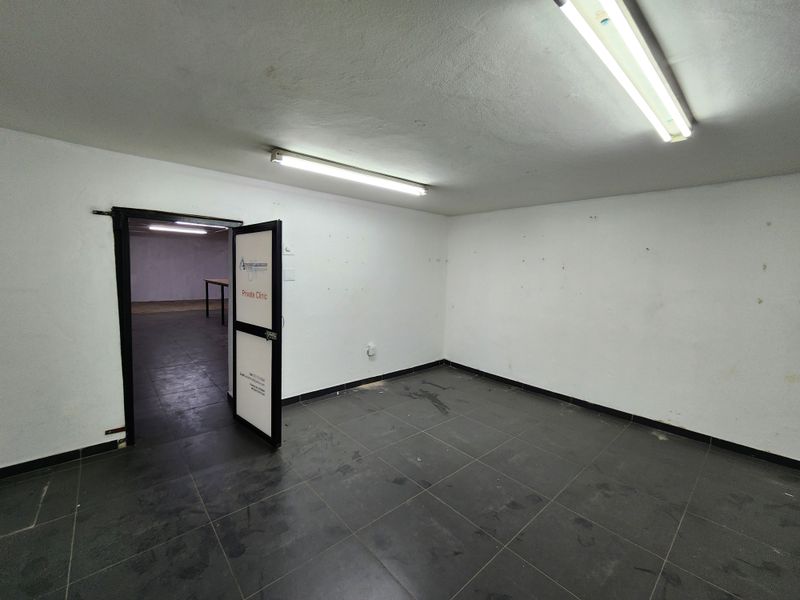 An empty utility or office space featuring tiled flooring and fluorescent lighting, suitable for various commercial or retail applications.