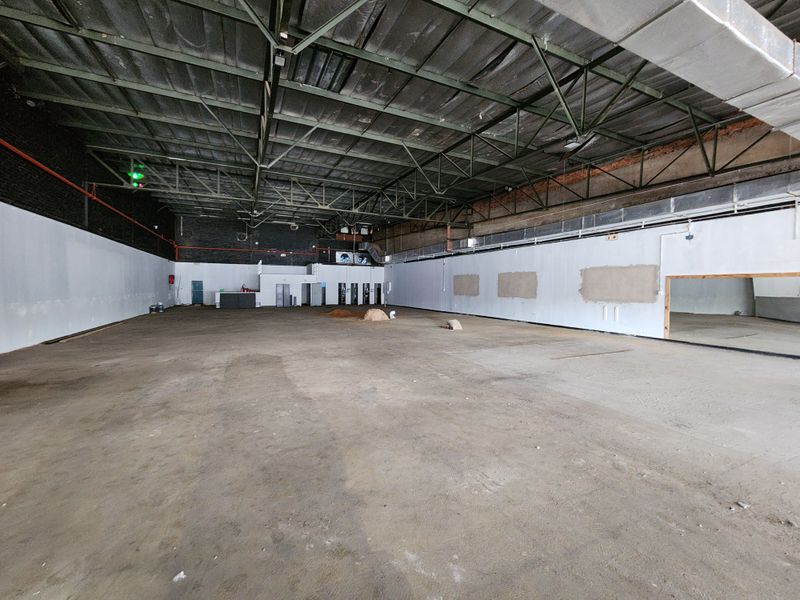 Large open-plan retail space featuring high ceilings with exposed steel trusses, concrete flooring, and industrial-style ducting, suitable for various commercial fit-out configurations.