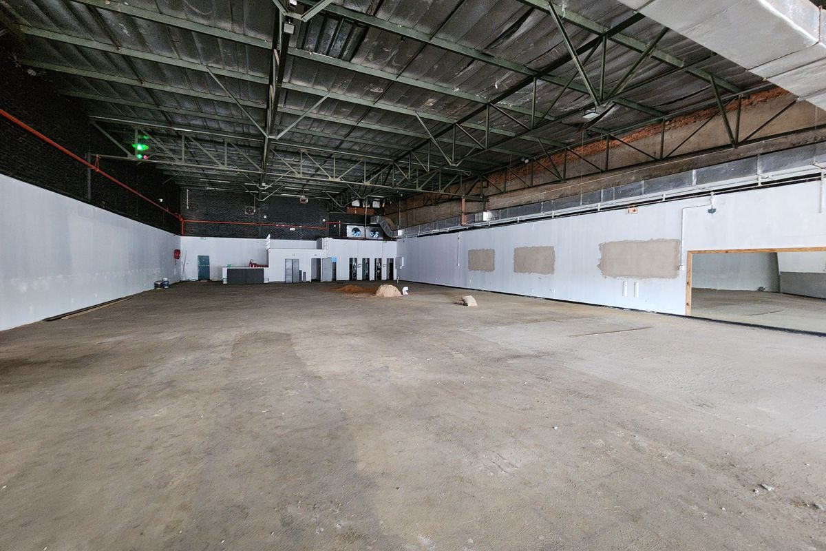 Large open-plan retail space featuring high ceilings with exposed steel trusses, concrete flooring, and industrial-style ducting, suitable for various commercial fit-out configurations.
