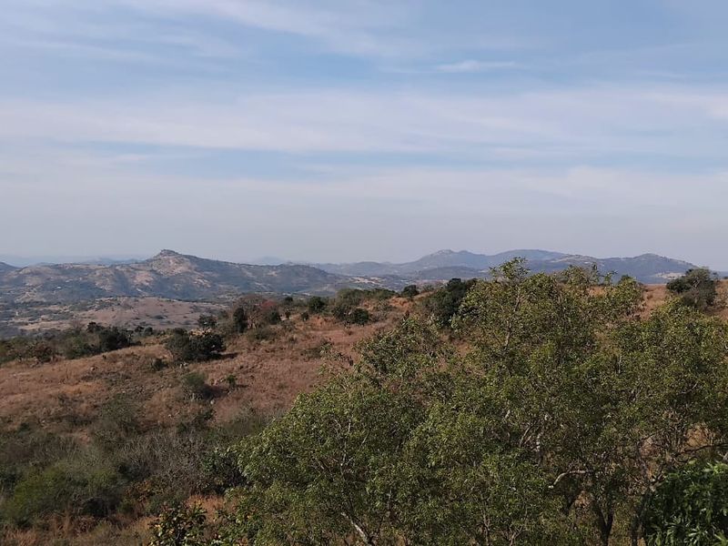 Expansive scenic view overlooking the natural landscape and distant mountain ranges, showcasing the rural setting of the small holding.