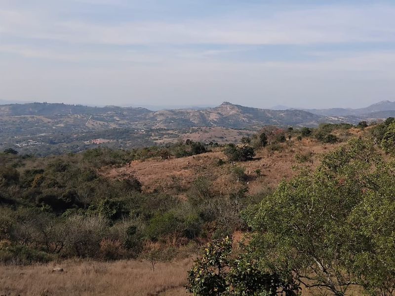 Expansive scenic landscape view overlooking rolling hills and natural vegetation, showcasing the rural character of the small holding.