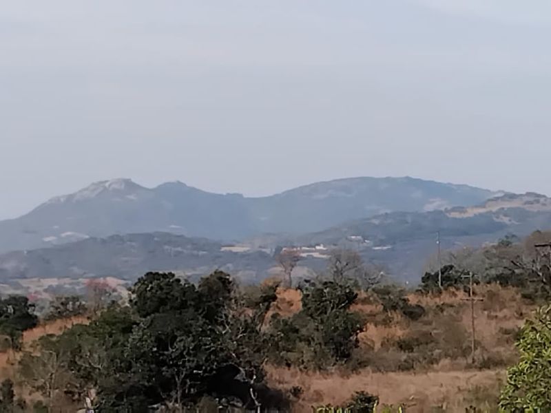A scenic landscape view showcasing rolling hills and mountain ranges, characteristic of the surrounding rural small holding environment.