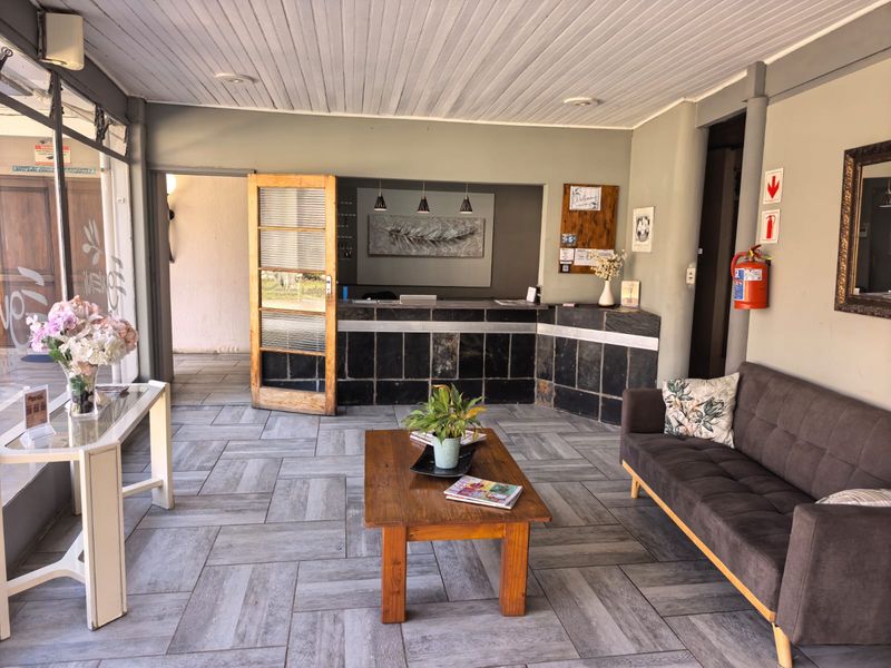 A welcoming reception area featuring a tiled floor, a built-in reception desk, and a functional layout suitable for guest check-ins.