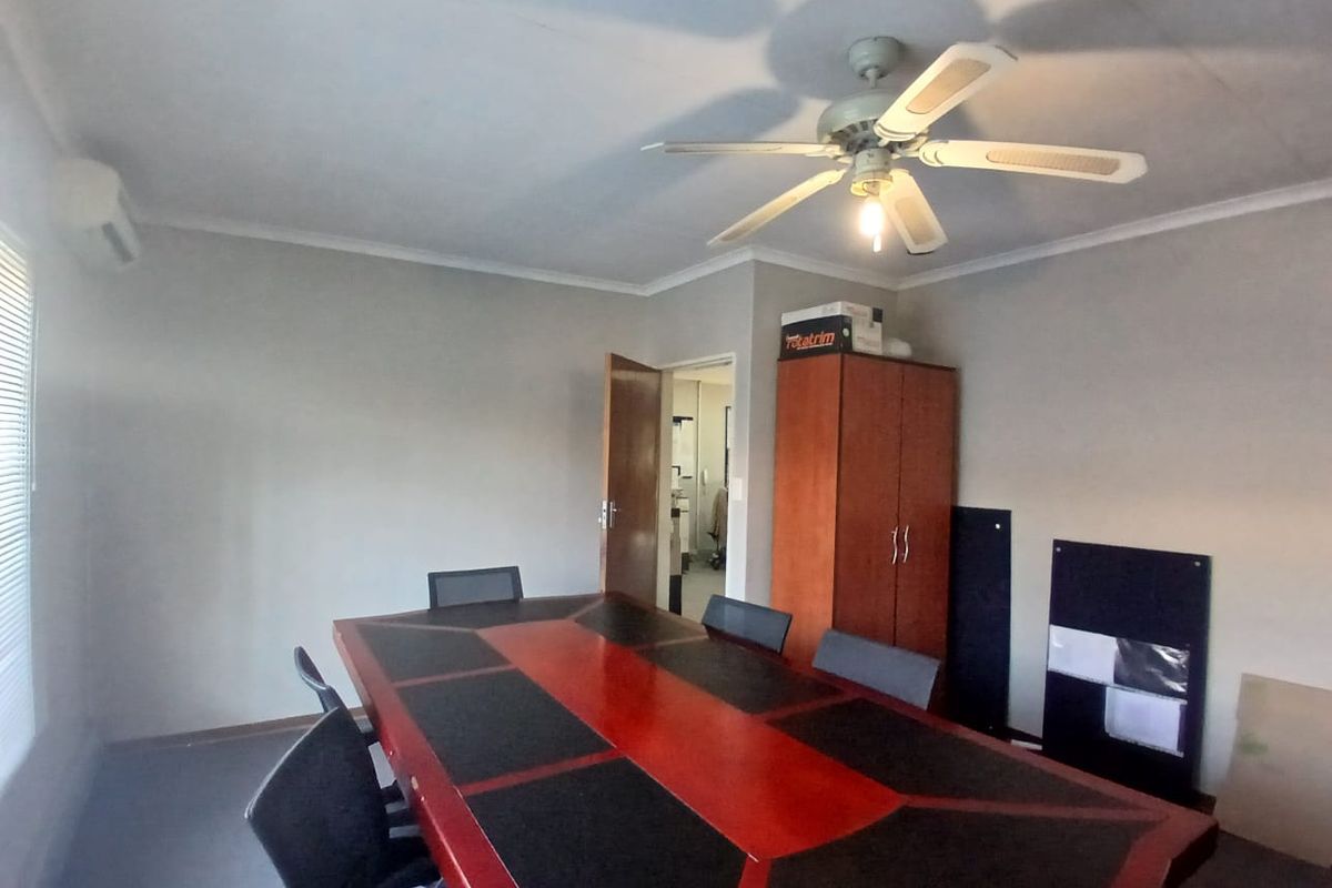 A functional office space featuring a ceiling fan, split-system air conditioning, and built-in storage cabinetry.