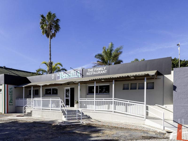 Front exterior view of a restaurant building featuring a covered entrance porch, accessibility ramp, and prominent signage.