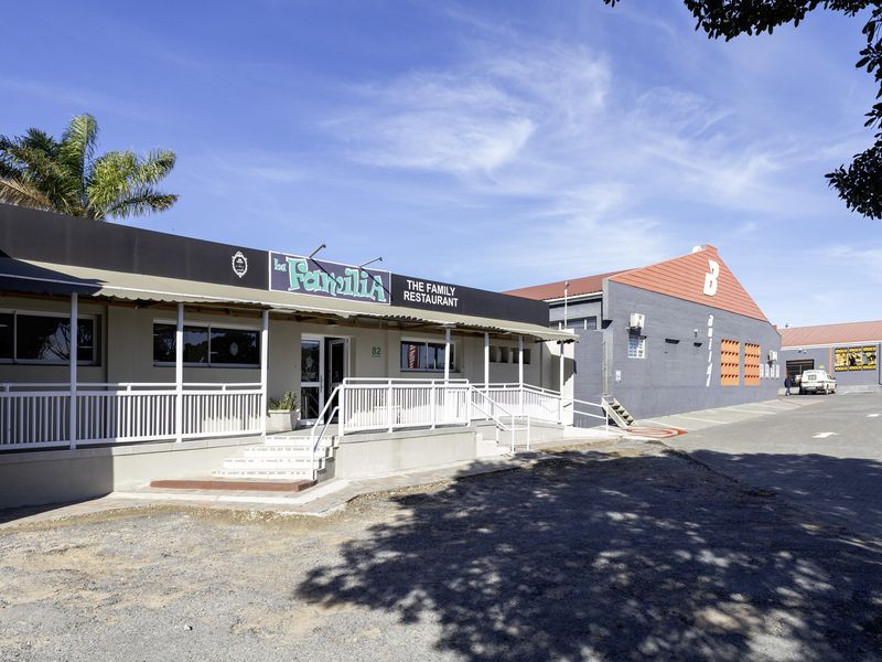 Front exterior view of a restaurant building featuring a covered entrance, accessible ramp, and prominent signage.