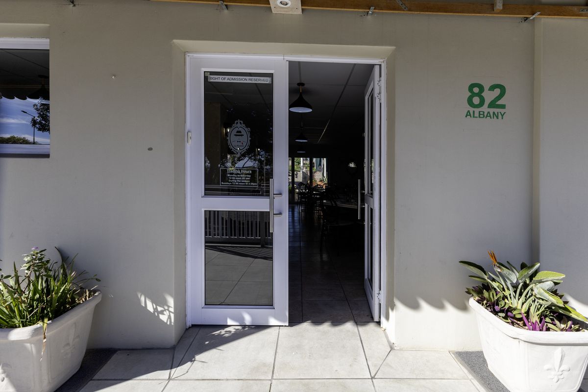 The front entrance of the restaurant features a glass panel door, tiled flooring, and clear building signage.