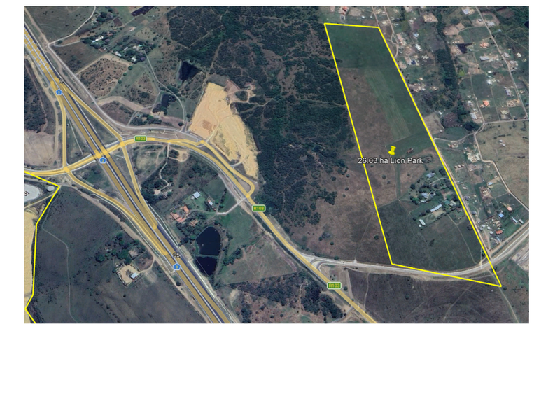 Aerial view of a 26.03-hectare vacant commercial land parcel located near major highway infrastructure.